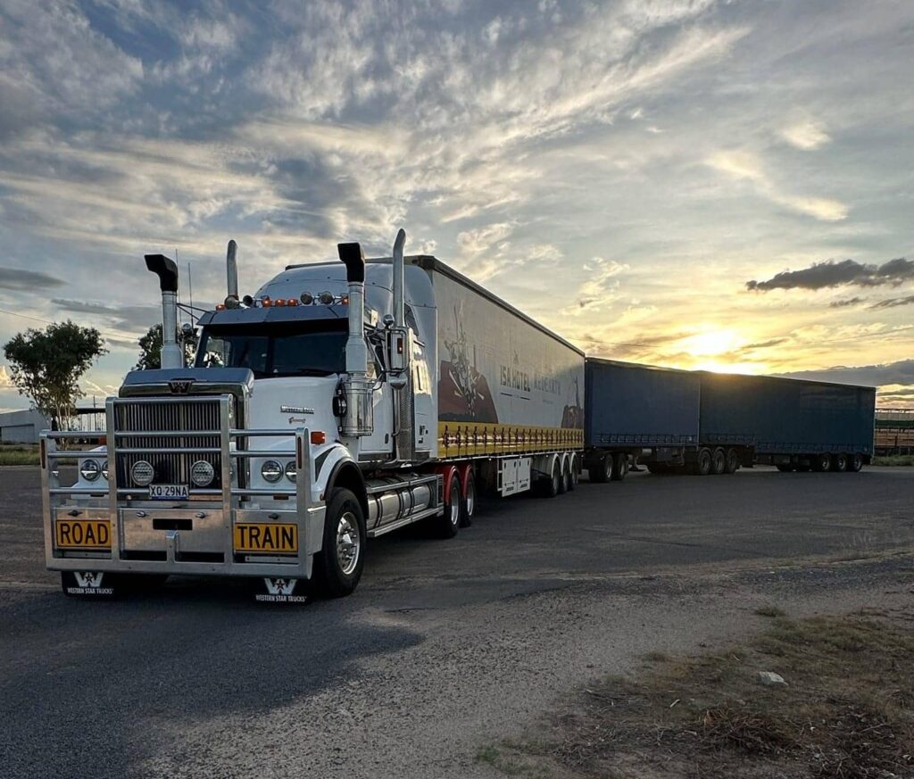 large freight moving truck parked with sunset in the background