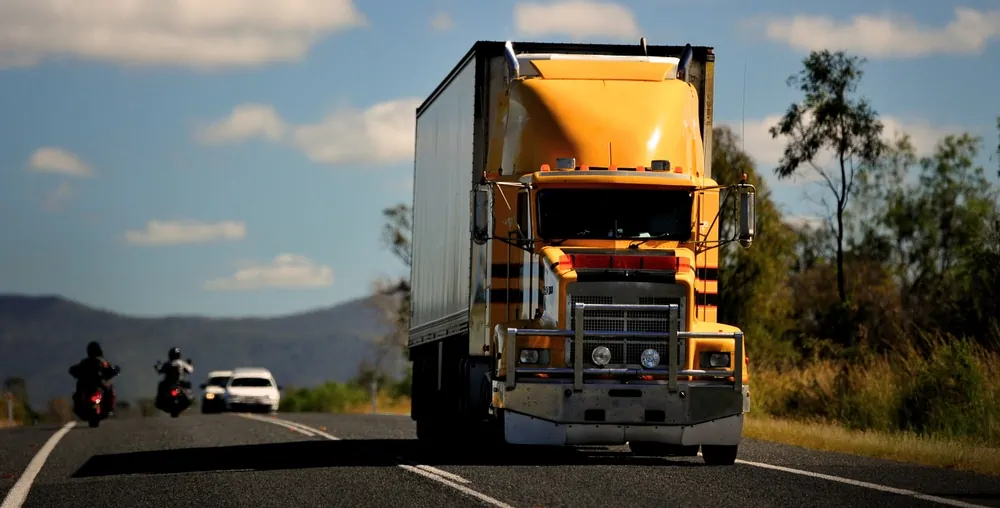 Large yellow freight forwarders truck on the road
