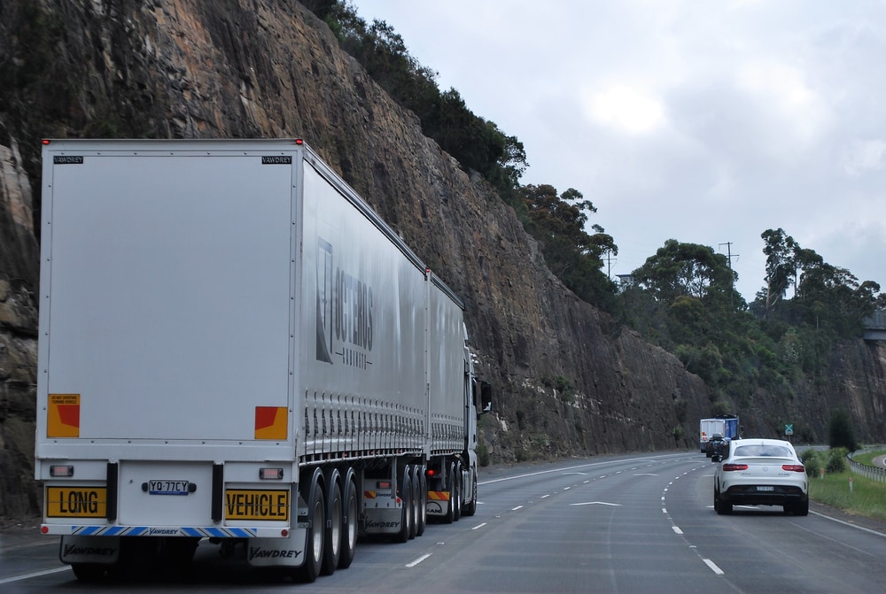 oversized load transport truck on the road with private cars