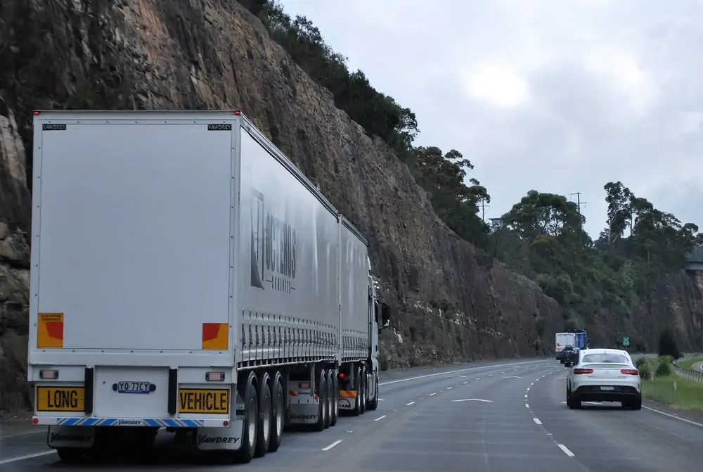 transport truck on the road with private cars